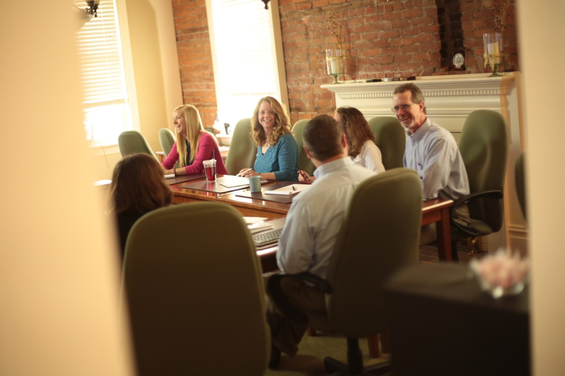 A group of Dering team members around their conference room table in disucssion.